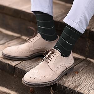 feet with black socks and beige white leather shoes
